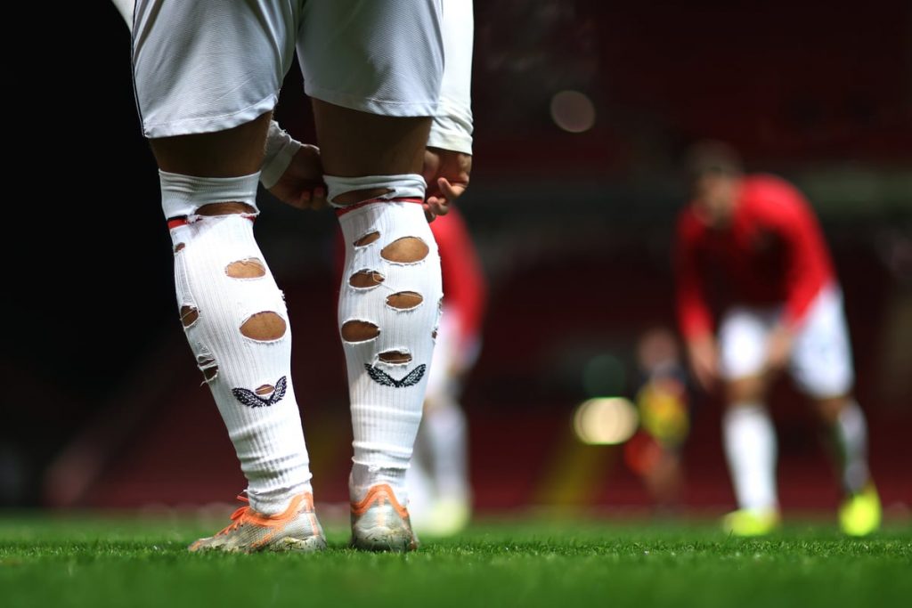 Why Do Footballers Cut Holes In Their Socks?